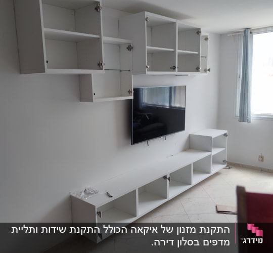 ארונות לבנים מותקנים על קיר עם טלוויזיה